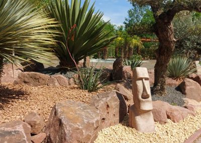 Egzotikus sziklakert olajfákkal, jukkákkal vörös sziklákból építve