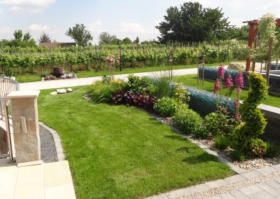 Flamingó Panzió: a parkban gyepes terület köti össze a virágágyásokat a burkolatokkal.