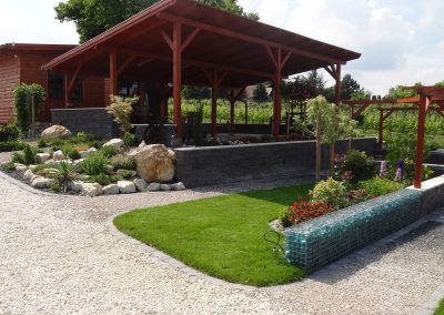 Flamingó Panzió parkja Etyek - étkező hely sziklakerttel, évelőágyásokkal és gabion támfallal.