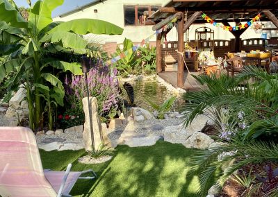 Téltűrő japánbanán és kanári szigeteki datolyapálma között vezet az út a kerti tóhoz