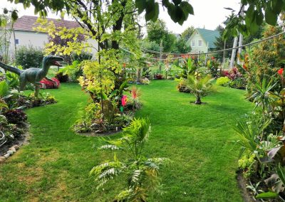 Trópusi bemutatókert, ahol dinoszaurusz dobja fel a kert hangulatát.